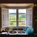 a kitchen with a double sink and open window